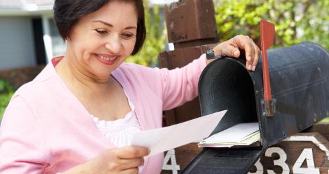 Woman smiling and checking her mailbox